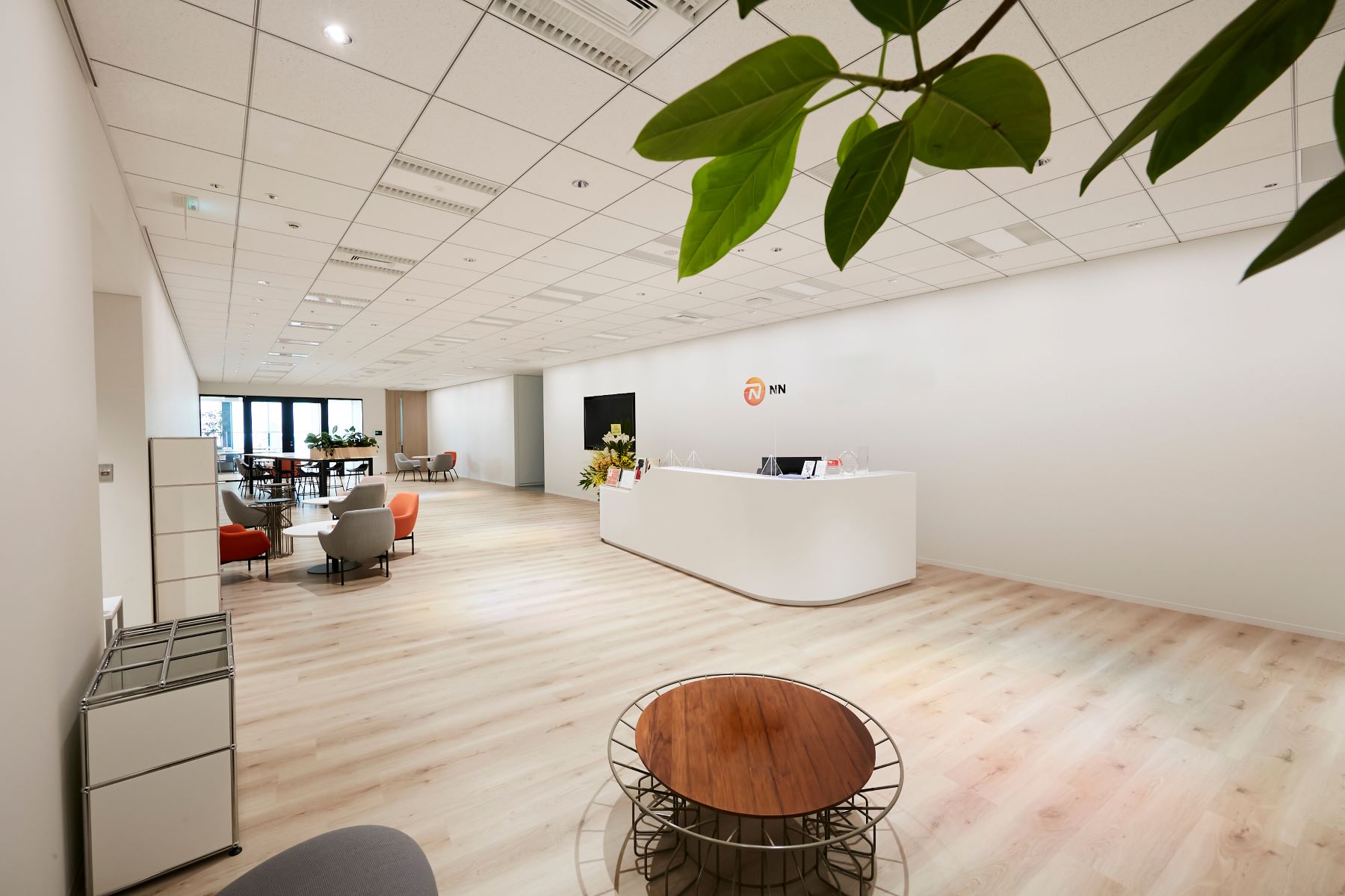 オフィスのロビーは白を基調としており、広く、すっきりしている。温かみがあり、かつデザイン性の高いチェアとテーブルが所々に配置され、モダンな印象を与えている。